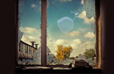 window with broken glass and an illustration of a helicopter with a glass cover in the background